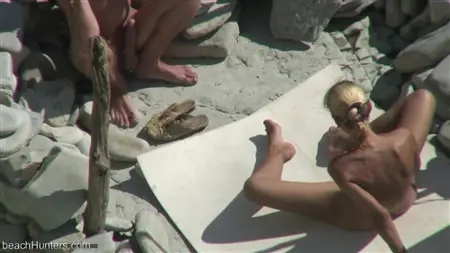 Bionda gioca con un membro del fidanzato su una spiaggia per nudisti
