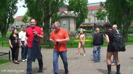 Una bionda carina con una figura sportiva nuda scatta foto con gli uomini