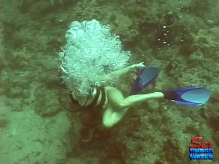 Un acqualangista nudo è alla ricerca di tesori nella parte inferiore dell'oceano