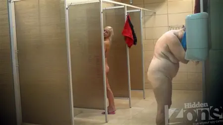 Una bionda snella è lavata in un'anima pubblica con donne grasse