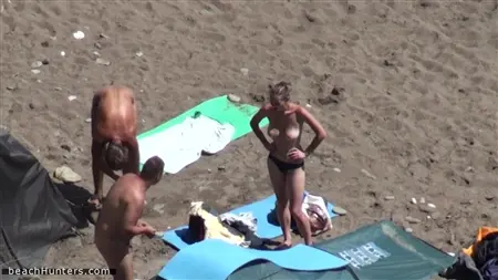 I nudisti avidi si godono una vacanza sulla loro spiaggia selvaggia preferita